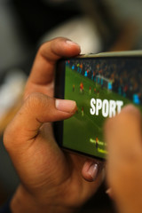 attractive hands playing sport video on a smart phone