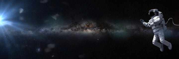 Naklejka na ściany i meble astronaut in empty space in front of the Milky Way galaxy