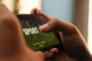 attractive hands playing sport video on a smart phone