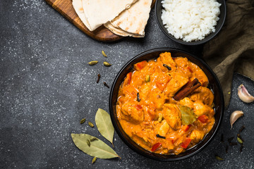 Chicken tikka masala with rice on black top view.