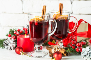 Mulled wine in glass mug with fruit and spices on white.