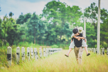 Cheerful excited glad careless happy young couple. Handsome young man giving piggy back ride to his girlfriend
