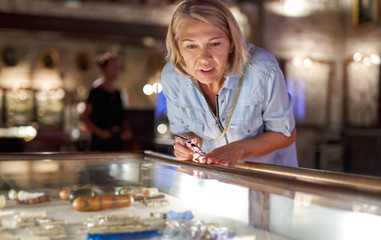 Woman visitor in the historical museum looking at art object.