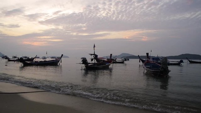 Scenery of Rawai beach during sunrise with many long tail boat in the andaman sea, Phuket, Thailand.
