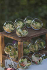 buffet catering salad in a glass plate on a wooden stand
