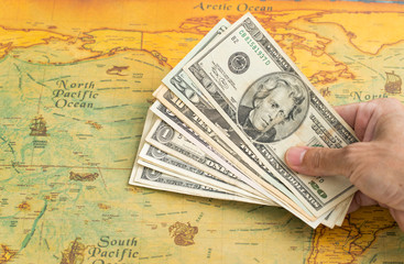 Money for travel Hand holding US. dollar with vintage map