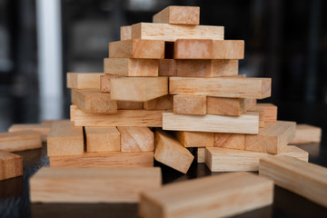 Wood block pile with architecture model with classic black tone background, Concept Risk management and strategy plan, growth business success process and team work