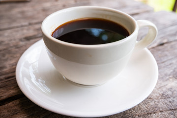 A cup of black coffee on the wooden table