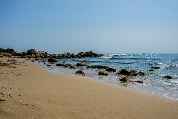 Fototapeta na wymiar Beautiful wild beach landscape, sunny day, water waves hitting the cliffs, nature summertime scene