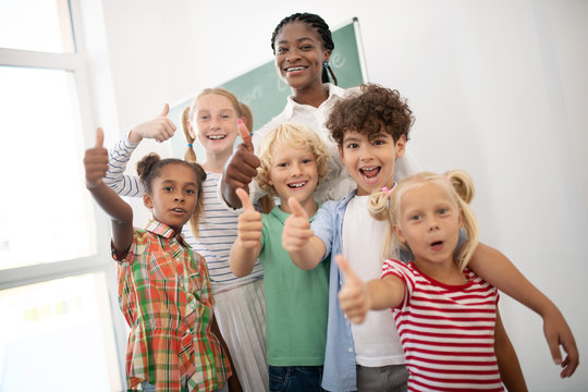Children showing thumbs up while feeling amazing after lesson