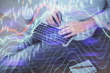 Forex graph with businessman working on computer in office on background. Concept of analysis. Double exposure.
