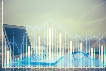 Stock market graph on background with desk and personal computer. Double exposure. Concept of financial analysis.