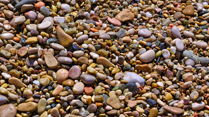 Beach colorful pebbles close up panorama background.