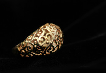 gold ring on a black background, close-up.