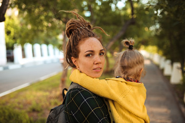 mom with dreadlocks shows the city to the child