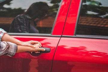Close up hand of asian mother or parent helping son or pupil to getting in the red car to ride to...