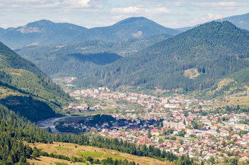 Fototapeta premium Ukraine Carpathians, a settlement in a valley of mountains, beautiful landscape aerial view
