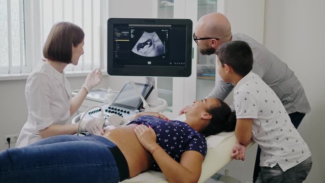 Pregnant woman and her family on utltrasonographic examination at hospital