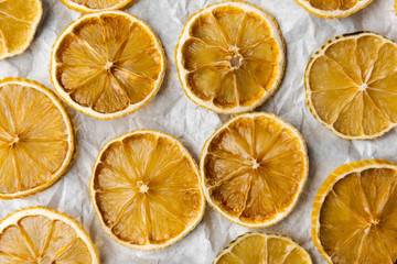 Fototapeta na wymiar Slices of dried lemons and limes lying on bright, crinkled paper