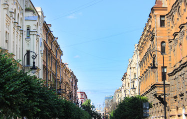 Fototapeta na wymiar Historic old house fronts on city street in Saint Petersburg, Russia. Sunny summer day view with ornamental building facades facing each other on cozy narrow street 