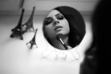 Girl doing makeup black and white