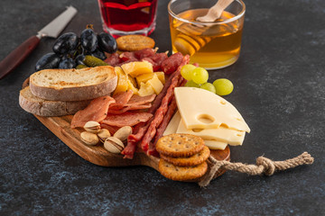 Italian food ingredients ham, salami, parmesan, olives, honey, bread.