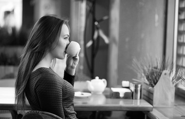 Girl in a cafe sitting and drinking tea