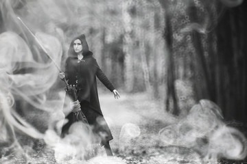 Obraz premium Woman in a witch suit in a dense forest