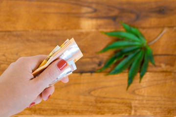 Cannabis leaf with euro banknotes on the table. Cannabis sale legalization concept. Point of view...