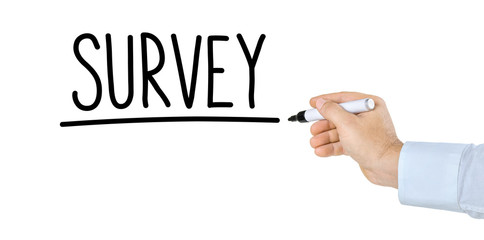Hand with pen writing the word Survey