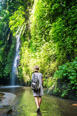 Woman near waterfal on Bali, Indonesia 