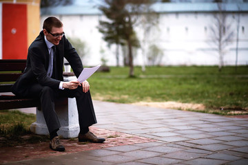 A man in a suit lies on a brick floor