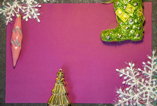 New Year's toys in the form of green Santa Claus boots and other toys on a red and pink background with white snowflakes. Behind black background. Fonk both for cards and congratulations..