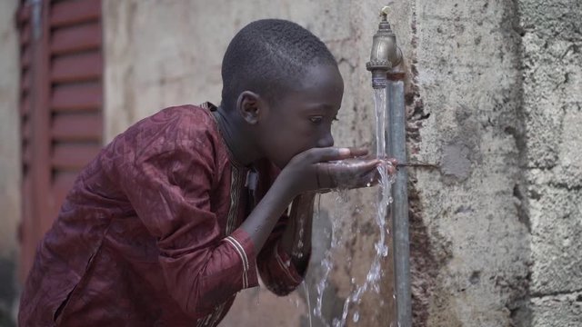 Handsome Little African School Boy Drinks Safe Drinkable Fresh Clean Water from Home Tap 