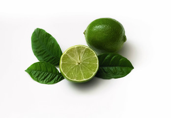 Lime green on white background. Ripe lime with leaves, cut in half close-up. Juicy refreshing fruit.