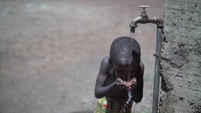 Handsome Little African Baby Boy Drinking Fresh Water under the Sun