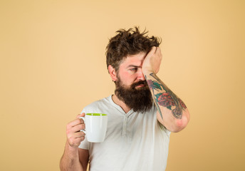 Tired sleepy man with beverage in cup. Morning refreshment and drink. Breakfast concept. Handsome...