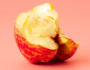 Bitten apple on a pink background