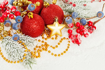 Christmas composition with  Xmas tree branch, red holly berries, golden garland and red baubles on...