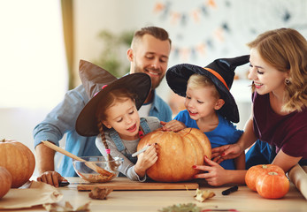 Fototapeta premium happy Halloween! family mother father and children cut pumpkin for holiday at home.