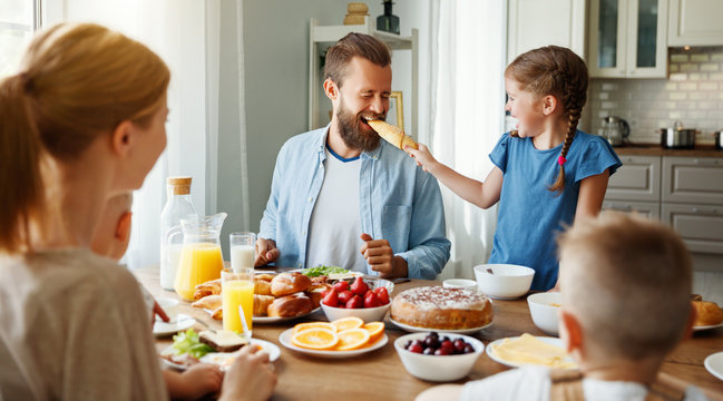 family mother father and children have Breakfast in kitchen in morning.