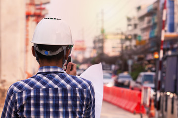 the engineer controlling the electric train is using radio to communicate with foreman in the construction project