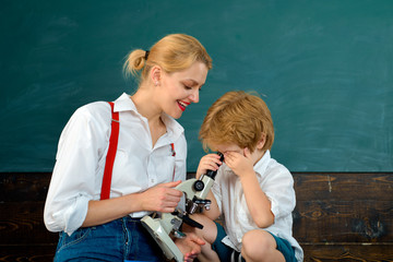 Science for children. The boy and his teacher. School and microscope. Look closer at things.