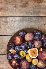Ripe Blue Plums and Ripe Figs on a Wooden Background Autumn Harvest Fruits Background Copy Space Top View Vertical