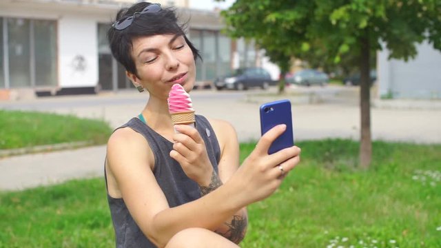 girl eating ice cream and taking photos on a smartphone