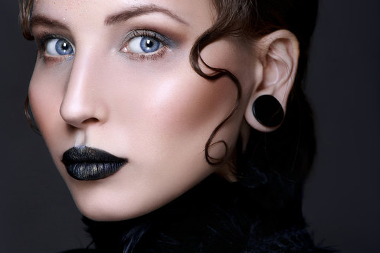 Black lips. Halloween Makeup. Luxury beautiful woman with dark lipstick and black feather collar. Beauty stylish gothic girl