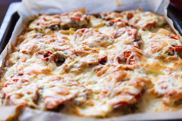 Baked vegetables with cheese sauce on a baking sheet in the oven. The view from the top.