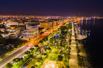 Fototapeta premium Republic of Cyprus. Night panorama of Limassol. View of Limassol from the drone. Illuminated promenade of the Mediterranean sea. Lanterns and palm trees on the waterfront. Trip to Cyprus.
