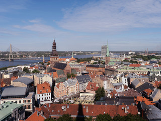 Fototapeta na wymiar Riga, Latvia. Summer. Panoramic view of the city. The streets of the old city aerial view. River, houses, old churches, blue sky. Postcard. Free space for text.