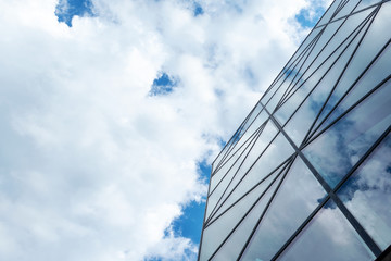 Fototapeta na wymiar Facade of a glass building. Cloudy sky Bottom view. Close-up. Architecture